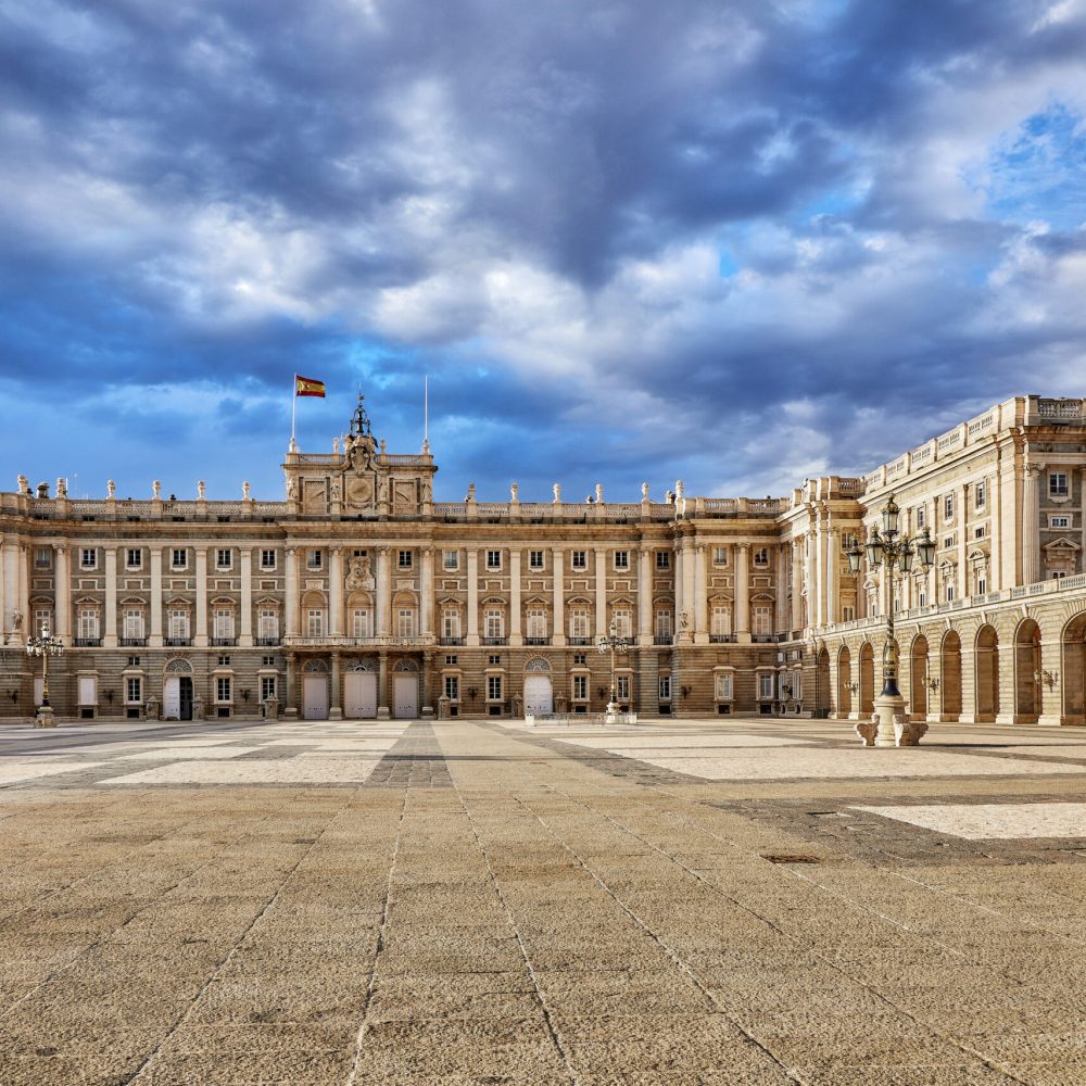 Royal palace in Madrid, Spain. Plaza de la Armeria, inner yard in front of building. Sunset with dramatic sky.
